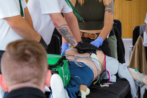 ACLS Instruktorenkurs: Ausbilder führt die Hände eines Teilnehmers bei den Thoraxkompressionen