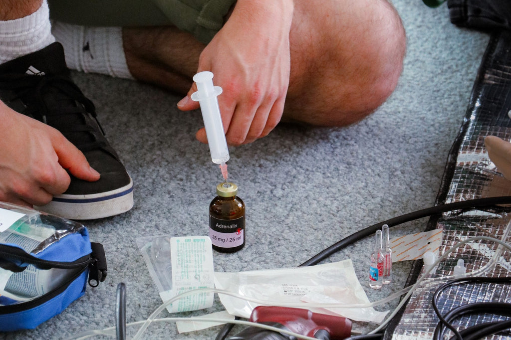 ACLS Refresh: Medikament wird aus der Ampulle in die Spritze aufgezogen