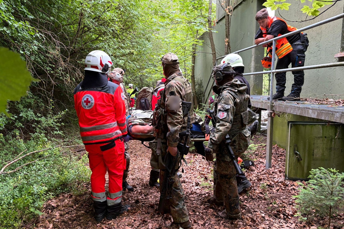 Zusammenarbeit von Rettungsdienst und Sicherheitskräften im T.R.A.U.M.A. Kurs: Transport eines Verletzten auf der Trage aus dem Gelände